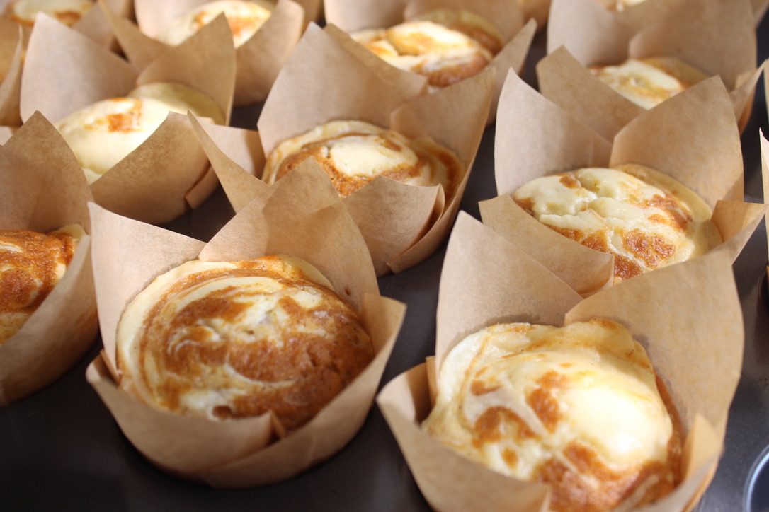 Cream cheese swirl muffins in tulip parchment liners
