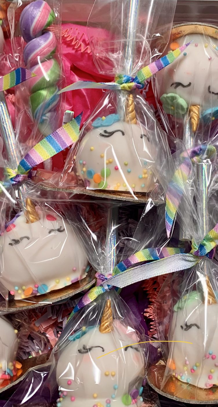 Unicorn cake pops wrapped in cellophane with rainbow ribbons